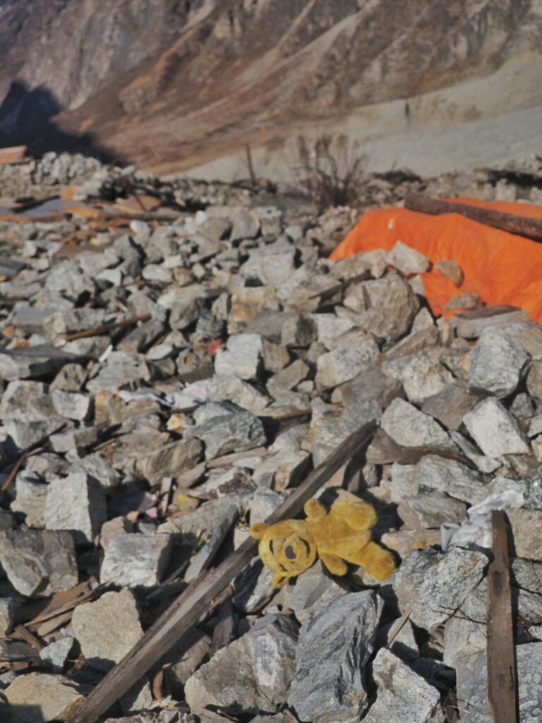 A lonely teddy bear laying around in the rubels where Langtang Village once used to be 