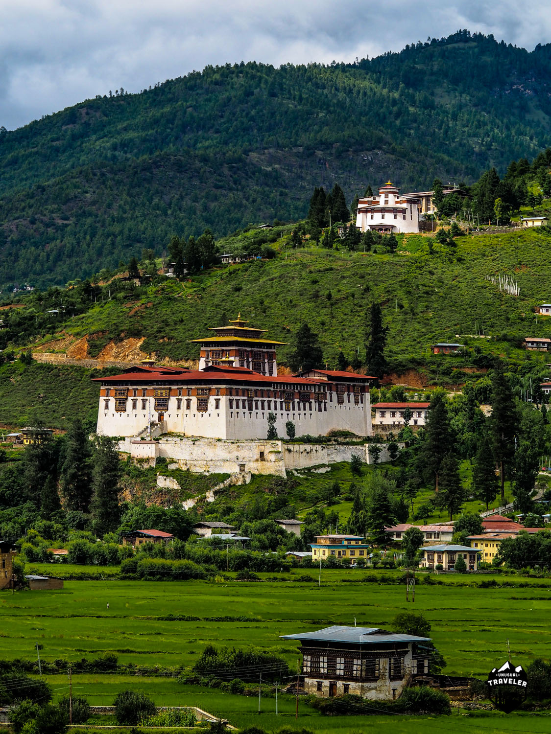 Paro Dzong and Bhutan National Museum in Paro Valley. Even the big city's is surrendered by nature and paddy fields. 