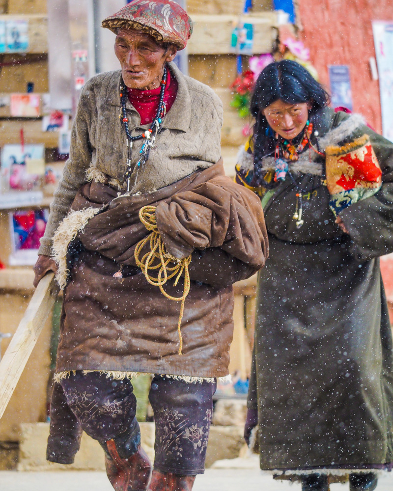 A older Tibetan couple coming trough the snow blizzard