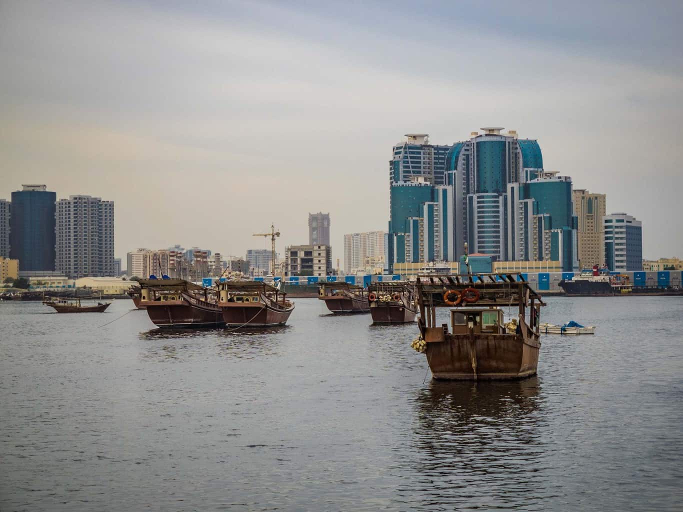 Traditional Fishing boats infront the the modern skyline in Ajman travel guide