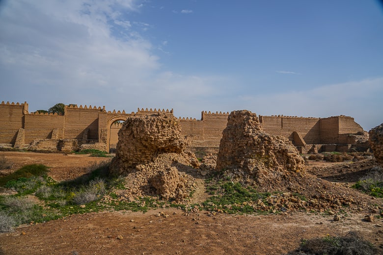 Crumbling ruins with the rebuilt ruins in the background.